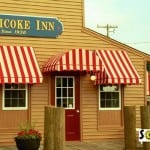 Traditional awnings over windows and a door with a half round awning.